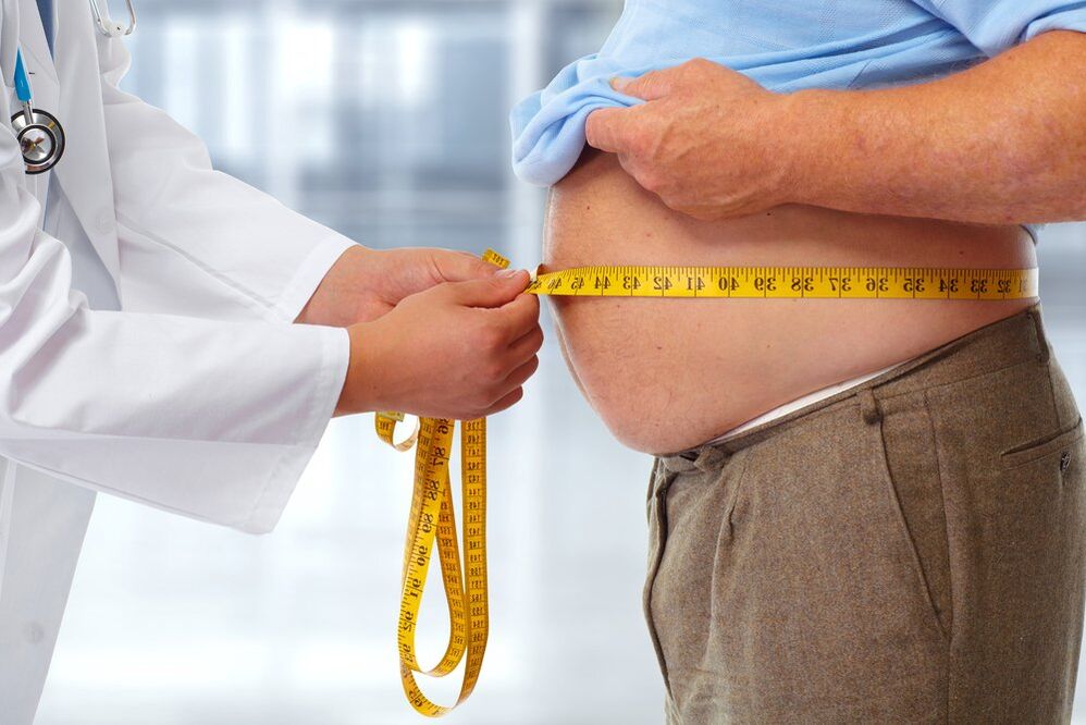 the doctor measures the waist of the patient on a diet