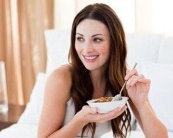 Girl eats porridge of thick wheat